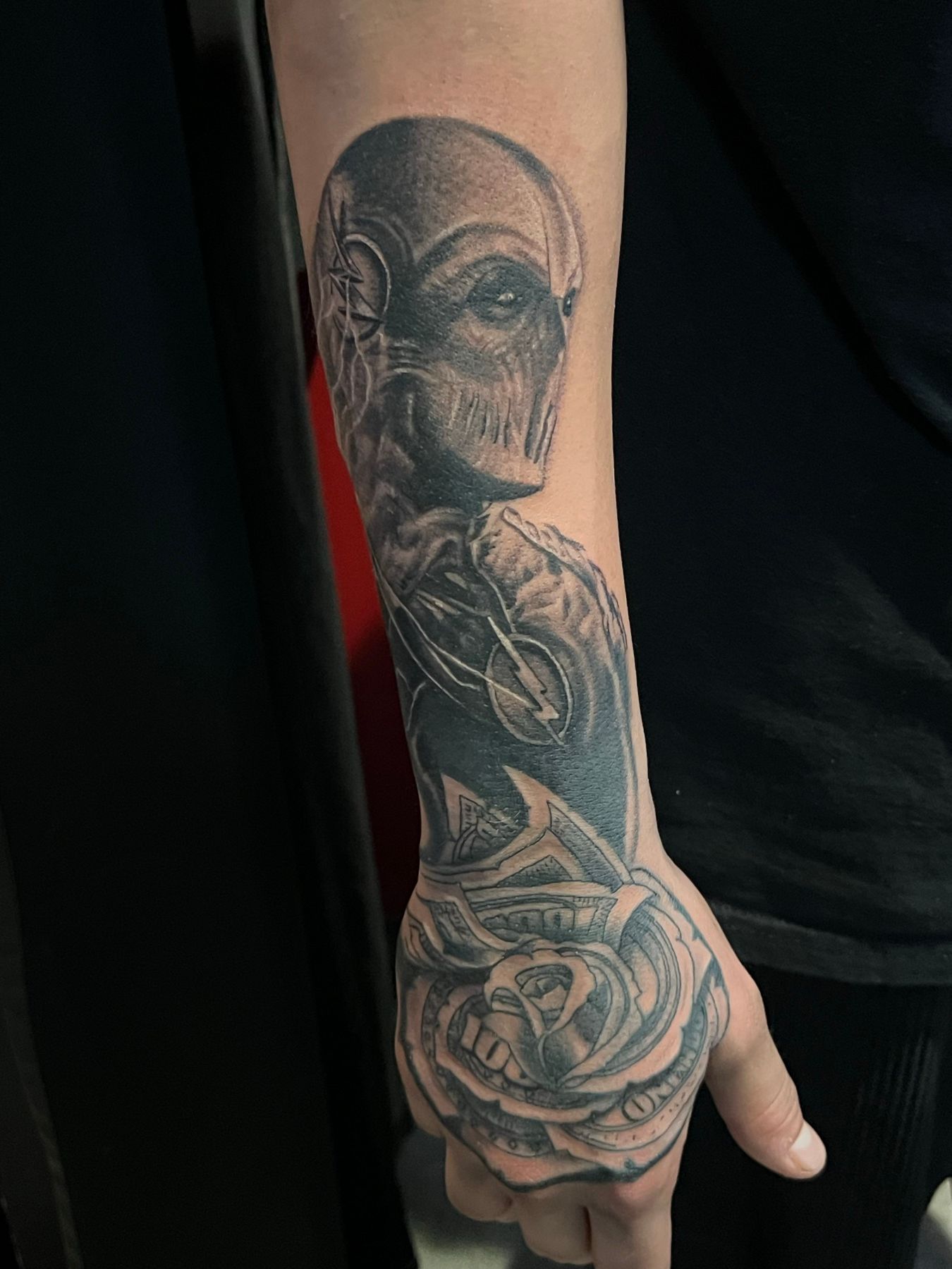 Black and grey sleeve tattoo of a skull, a ram and a rose running from forearm to hand, by American Ink in Sherman Oaks.
