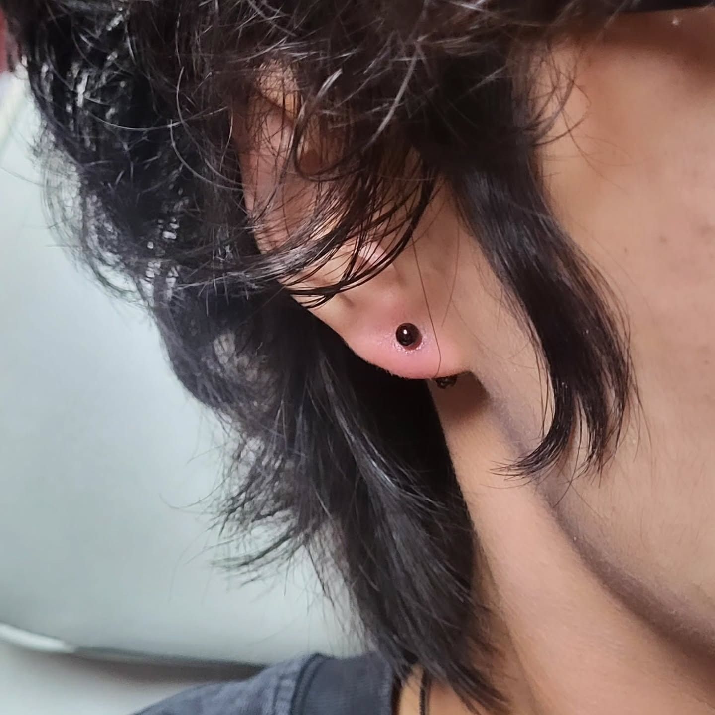 Healed earlobe piercing with a simple black stud, pierced by American Ink in Sherman Oaks.