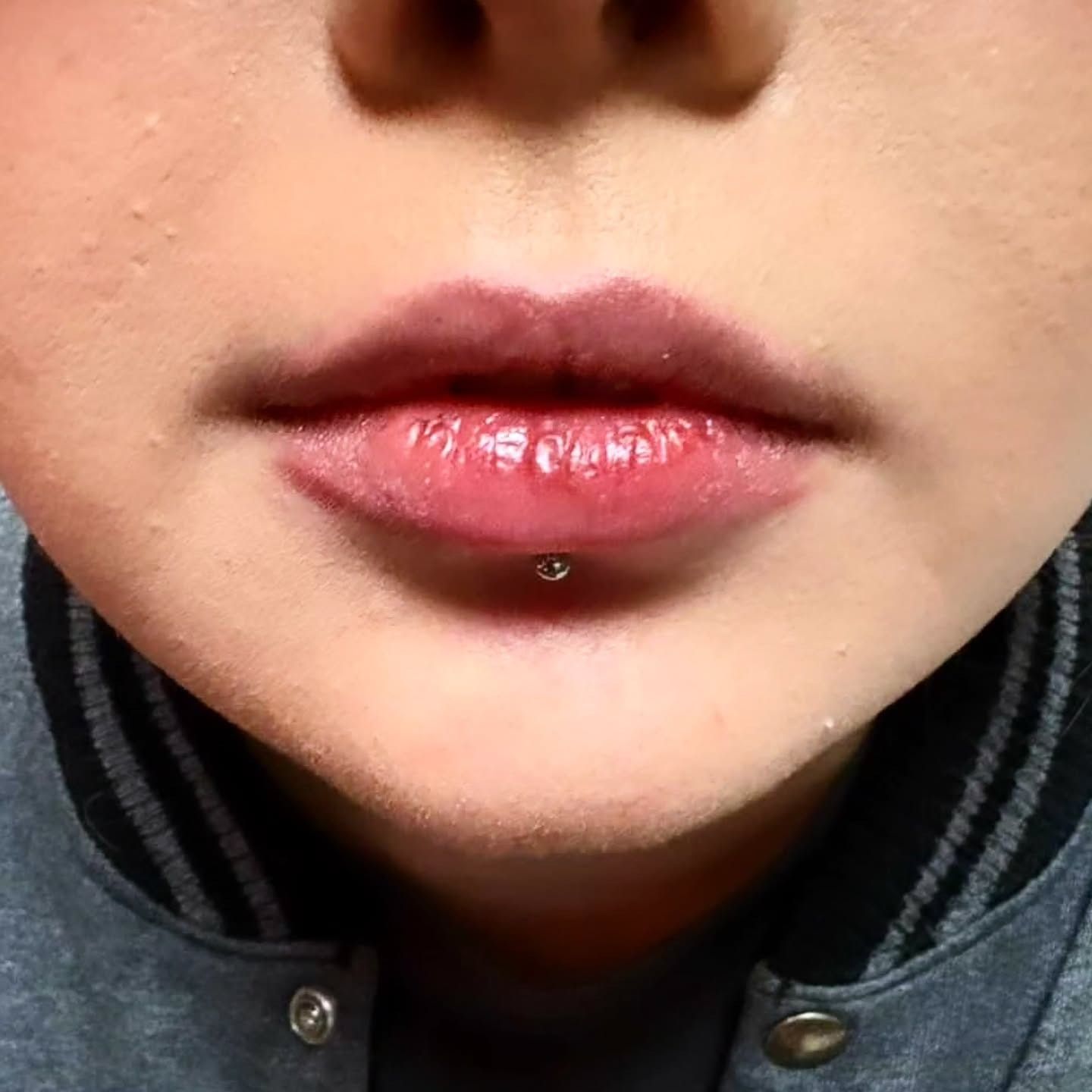 Close-up of a freshly pierced lower-lip labret with a steel stud, pierced by American Ink in Sherman Oaks.