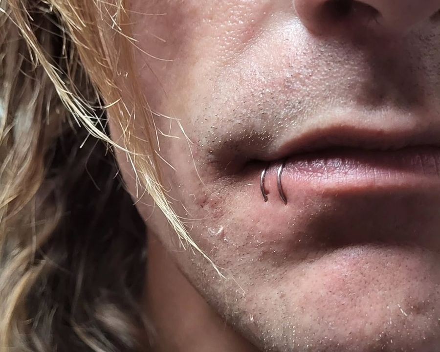 Paired lower lip ring piercings from the American Ink piercing studio