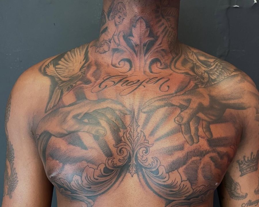 Full chest and neck piece with cherub, doves, and script lettering, tattooed by Josue
