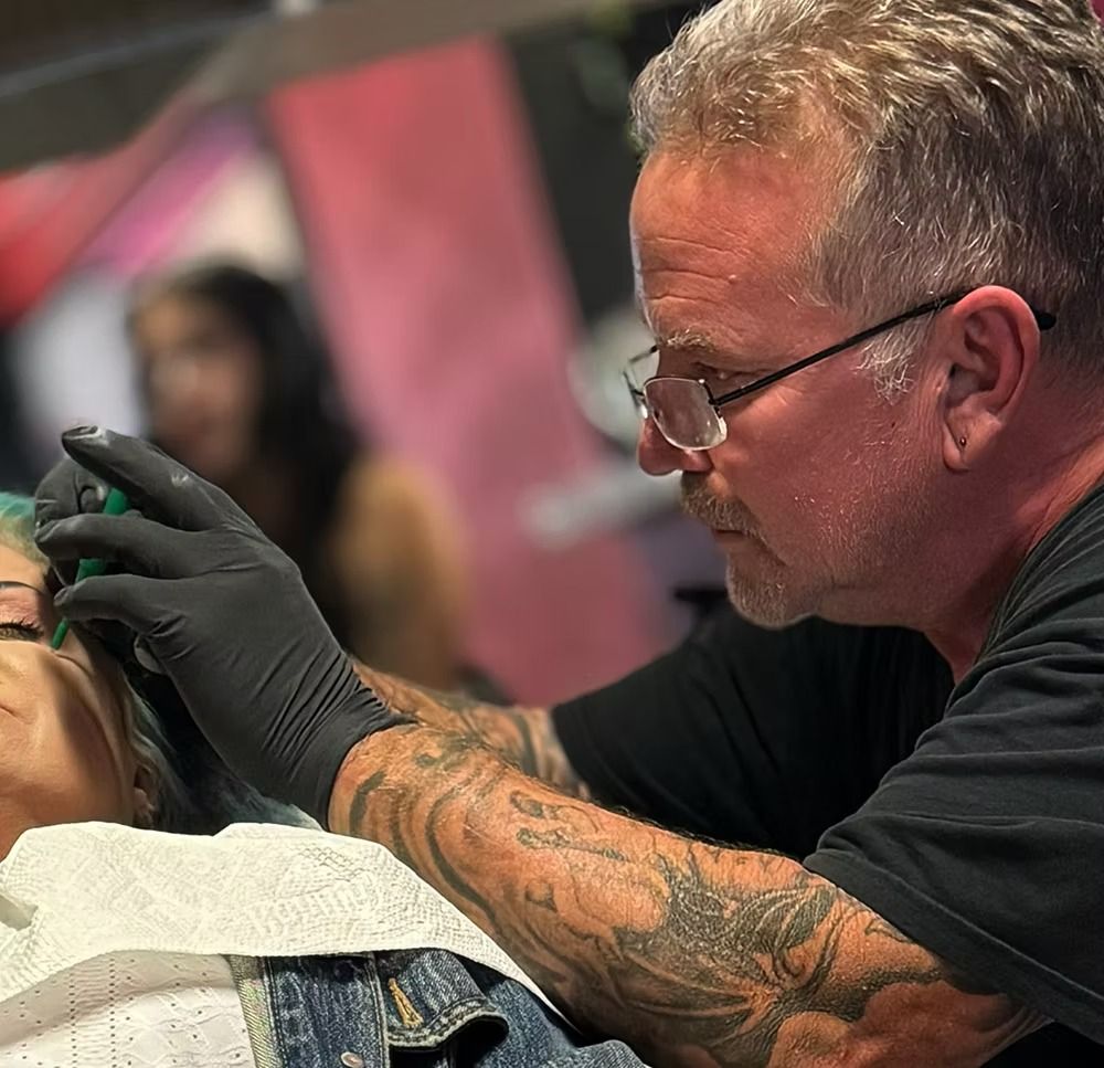 Piercer in black nitrile gloves carefully placing a facial piercing by hand at American Ink in Sherman Oaks.