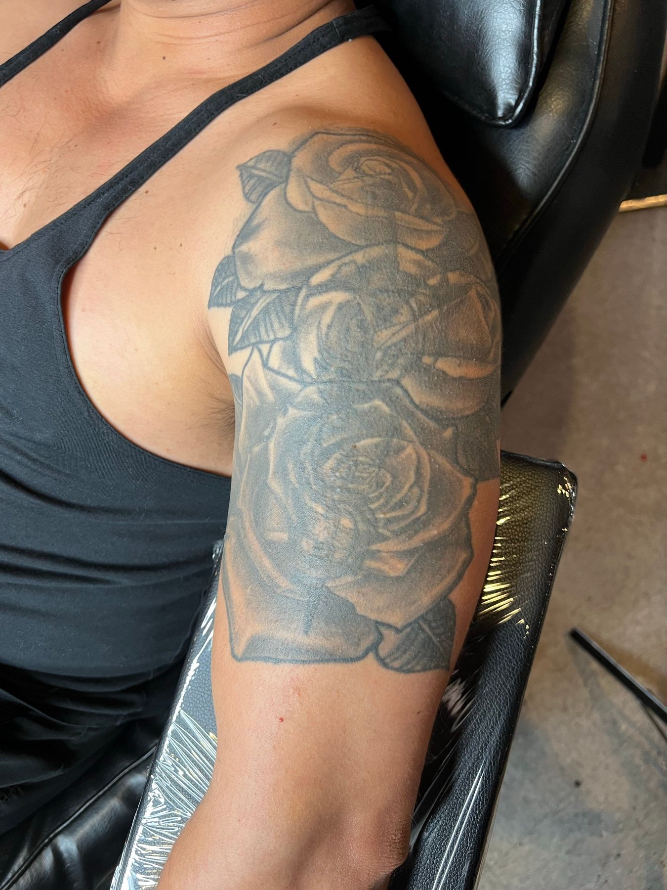 Faded black and grey rose shoulder tattoo with soft, washed-out shading before its rework at American Ink in Sherman Oaks.